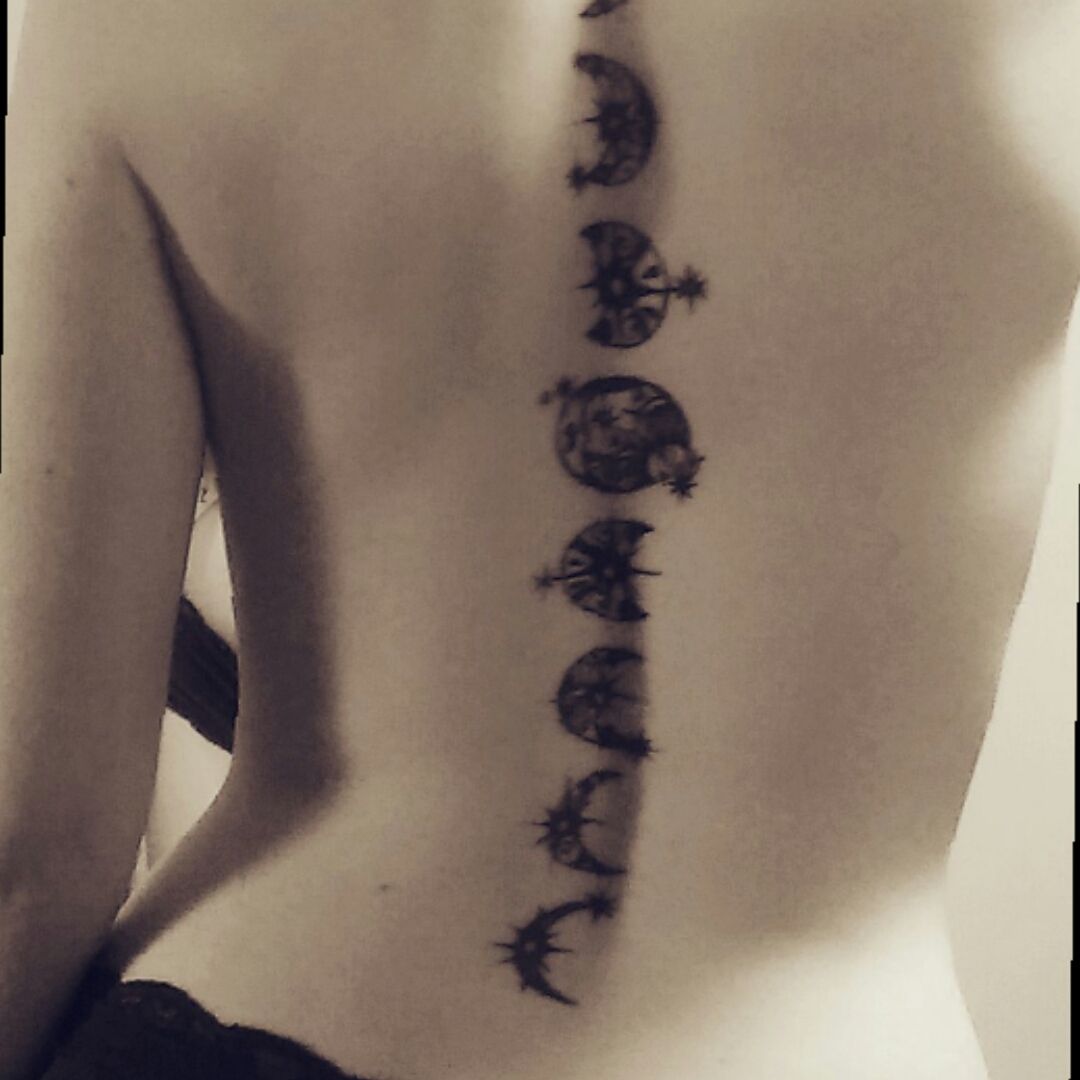 Moon phases tattoo located on the upper back