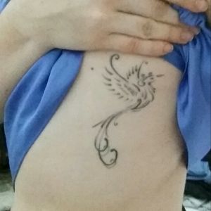 This one has a beautiful story. To make a long story short, my mom had cancer and I made this tattoo for her.There's a "V" on the phoenix' belly for "Vania" (my mother's name), "vida" ("life", in Portuguese) and "vitória" ("victory").The inspiration came from the song "The Wind Beneath my Wings", because my mom has always been the wind beneath my wings. She has always been there for me.Everything I am, I owe to her.