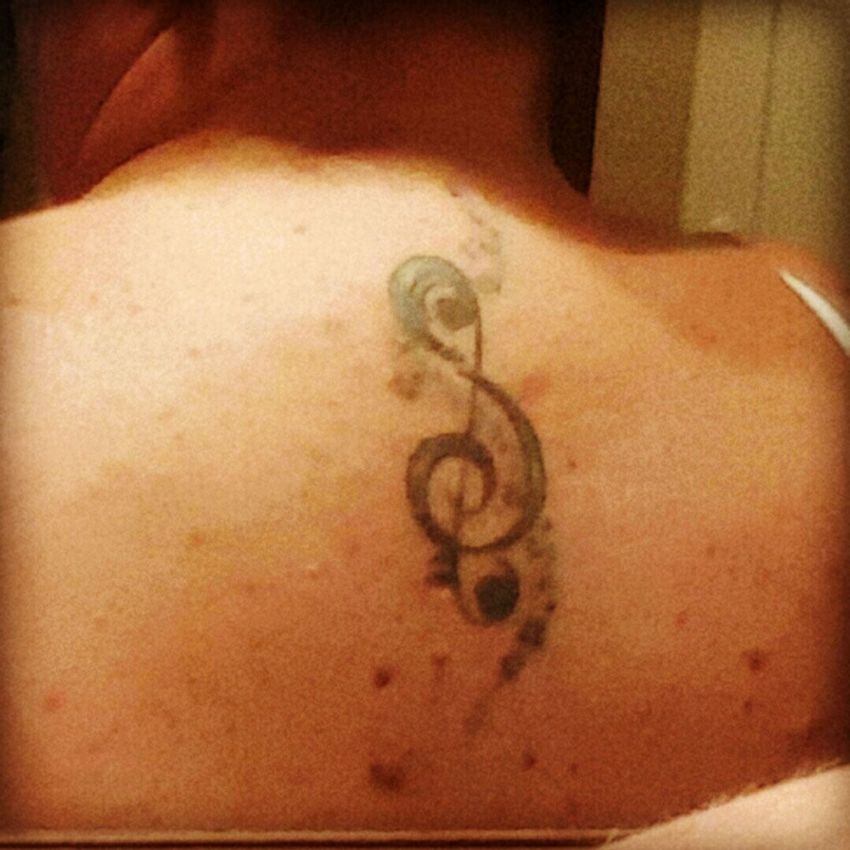 treble clef tattoo on neck