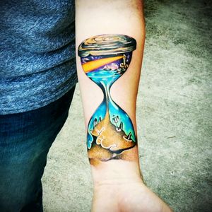 Surrealism tattoo. Story captured inside an hour glass. #surrealism #surreal #colorful #hourglass #lighthouse #water #sand