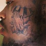 Face tattoo praying hands