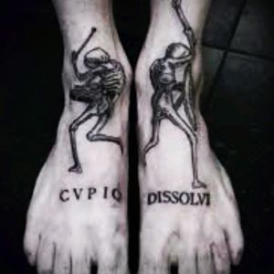 A beautiful two-piece foot tattoo with dancing skeletons and the Latin writing "cupio dissolvi", meaning "I want to be dissolved". #Latin #writing #skeletons #dancing #dancingskeletons #blackwork