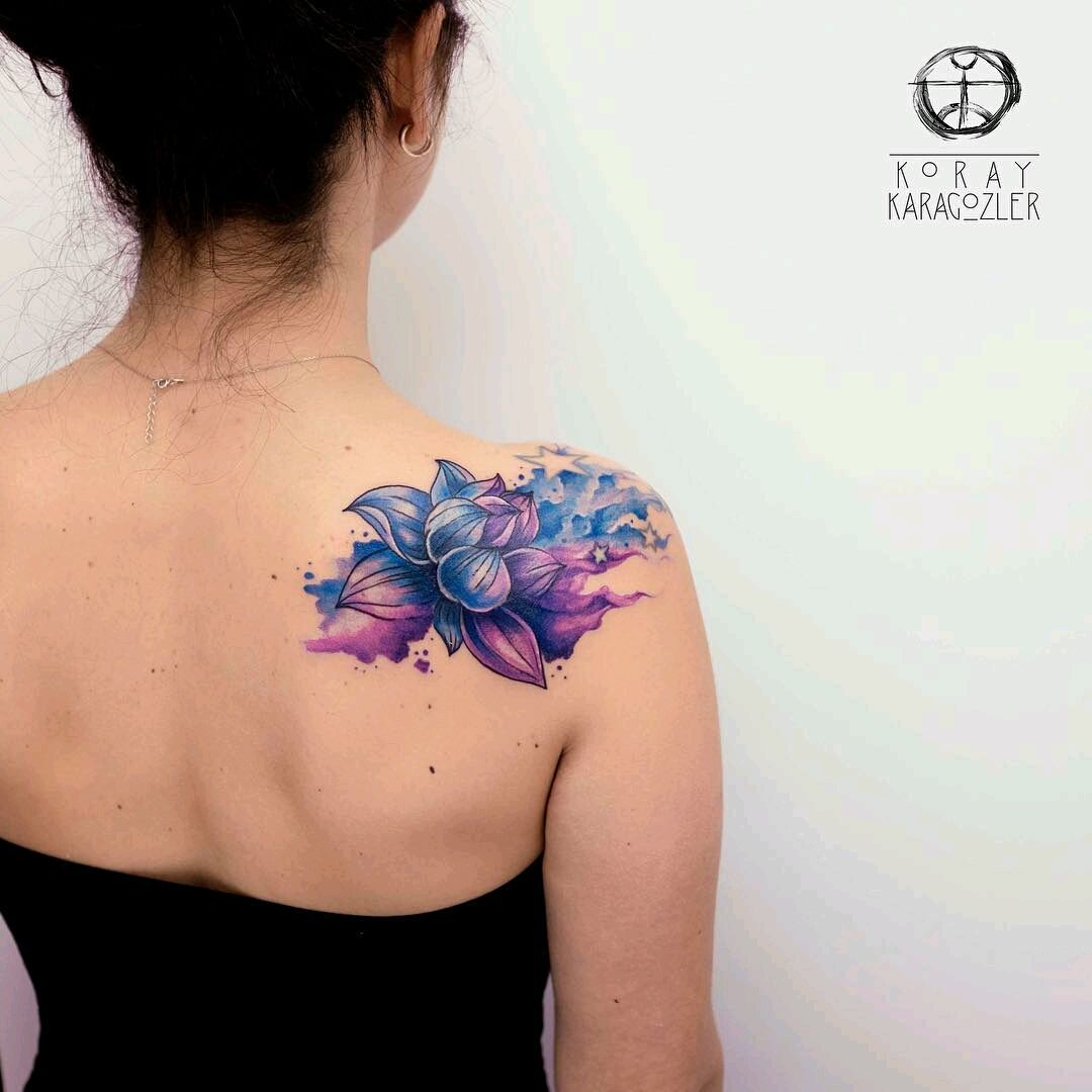 Watercolor style lotus flower tattoo on the right