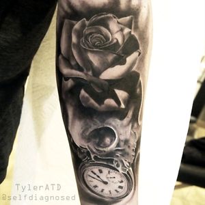 Forearm sleeve with clock, skull and rose.