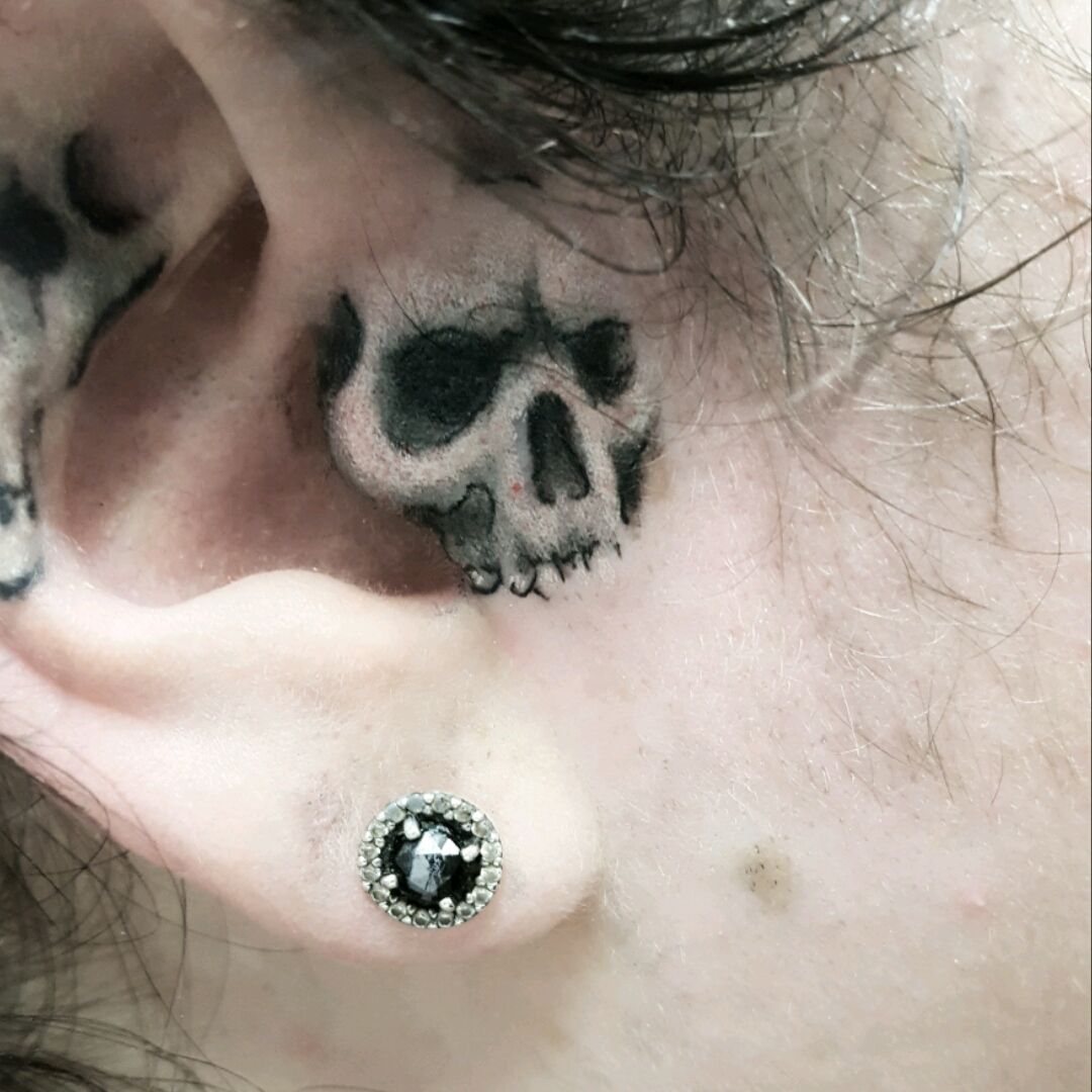 Black Danger Skull Tattoo On Left Behind The Ear