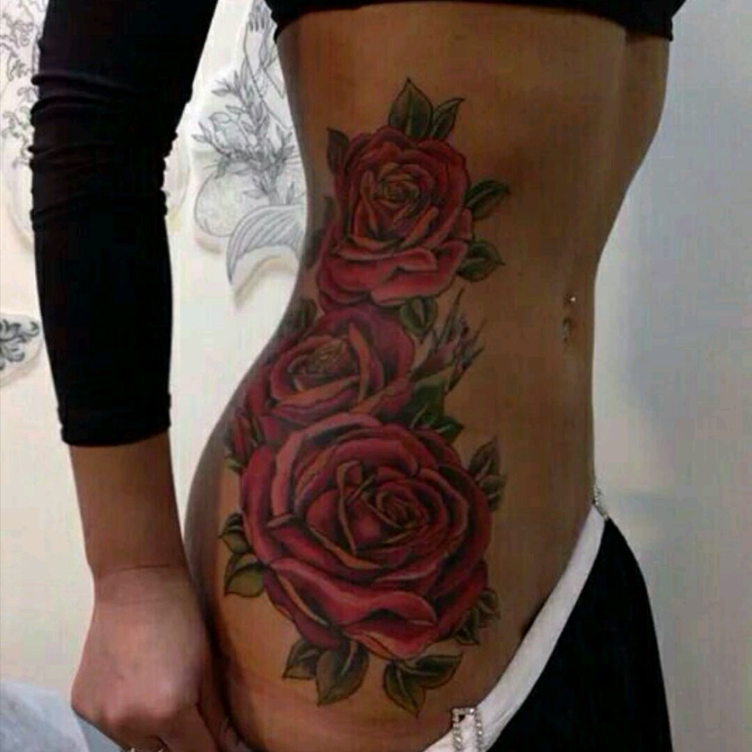 Single needle rose tattoo on the left side ribcage.