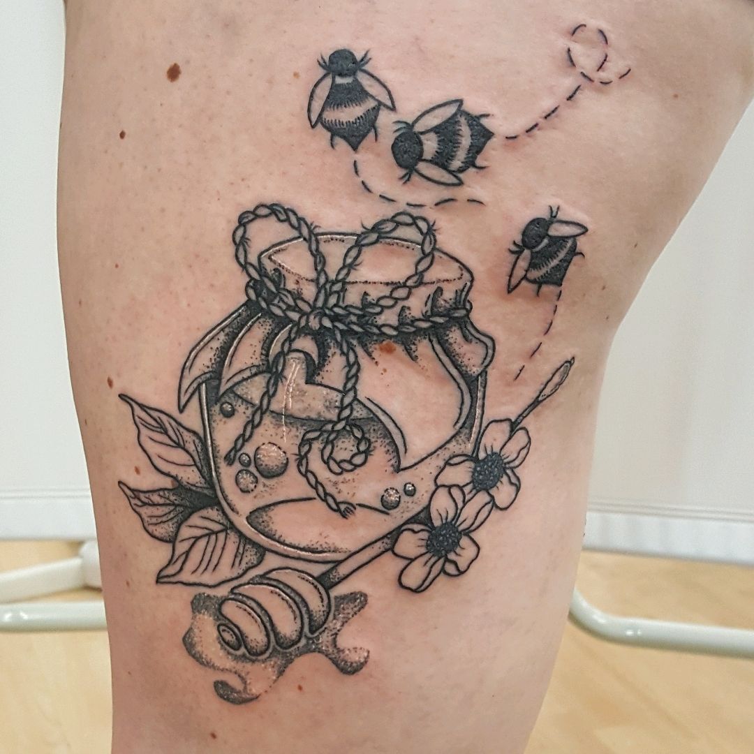 Honey pot tattoo on the back of the left arm