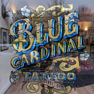 Blue Cardinal Tattoo gold leaf window sign. 23ct gold leaf, white gold and variegated leaf. With mother of pearl inlays. Hand painted in reverse on the inside of the window from a hand drawn sketch.