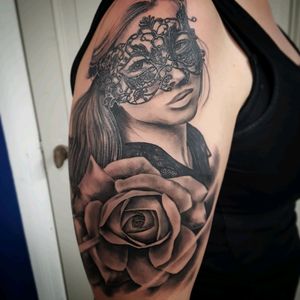 Masquerade women with a mask and rose. Black and gray realistic tattoo.