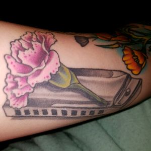 Harmonica and carnation on the inner bicep by Chris stoll at red five in Virginia beach.