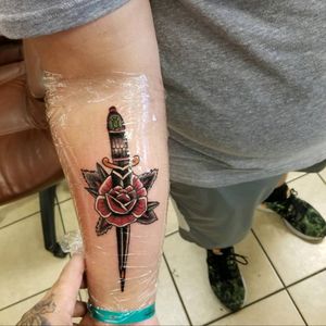 A dagger going through a rose tattoo with my dads birthstone on the hilt of the dagger.