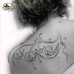 Tatouage arabesque courbe et ligne haut du dos femme pour souligner la belle courbe féminine du corps avec des perles et qui lui coule dans le dos