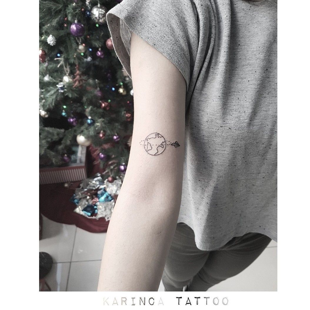 Minimalist planet earth tattoo on the tricep