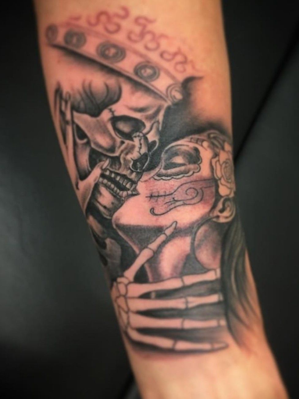 Skeleton kiss tattoo on the forearm