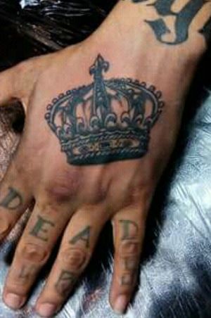 Hand tattoo. Black crown