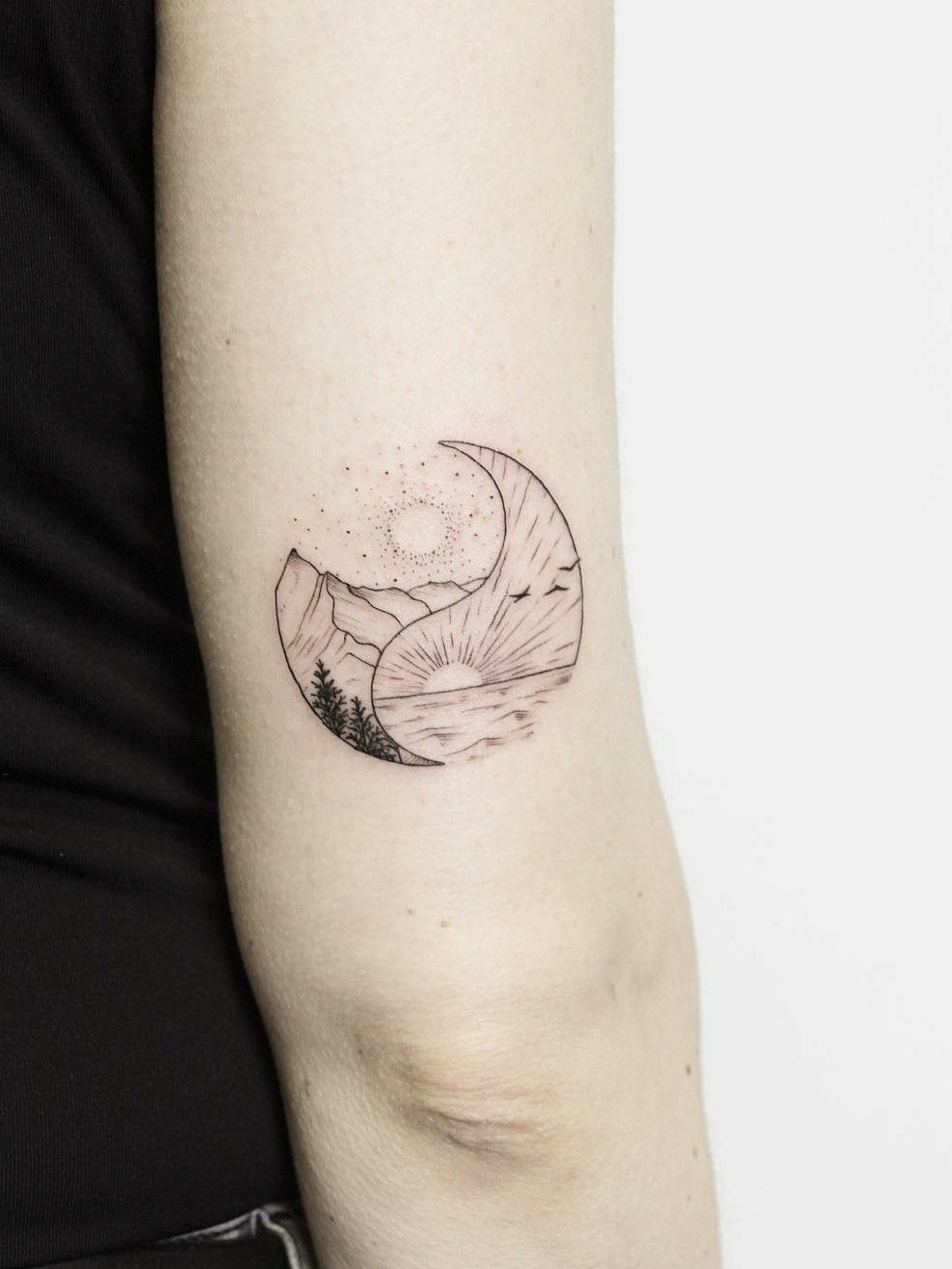 Mountain sun and moon tattoo located on the tricep