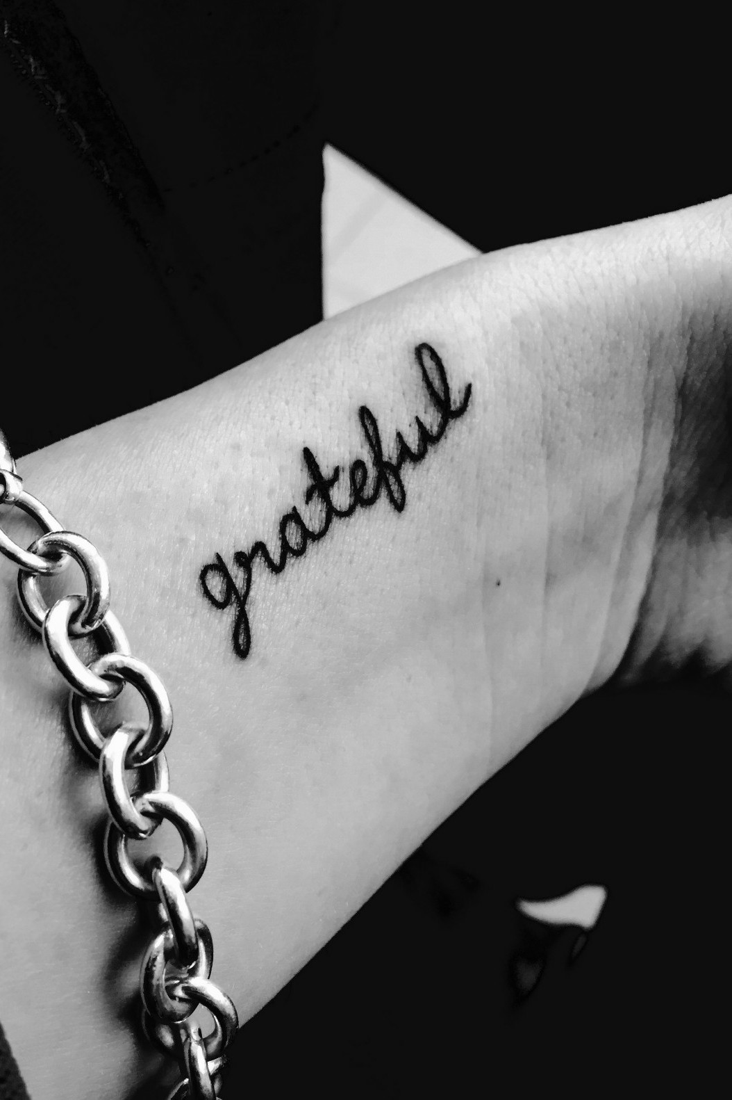 Grateful lettering tattoo on the inner forearm