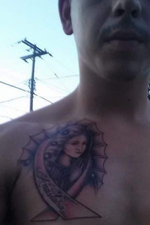 My second tattoo I got when I was 19. It is for my grandma because she beat breast cancer but unfortunately had to remove her right breast. So I got the virgin Mary and she has the breast cancer ribbon around her and I also put it on my right chest in honor of her sacrifice.