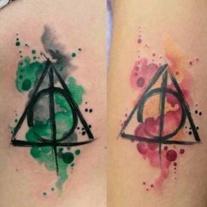 Uma tatuagem de Harry Potter que junta as relíquias da morte, com as duas casas mais famosas (Slytherin e Griffindor)