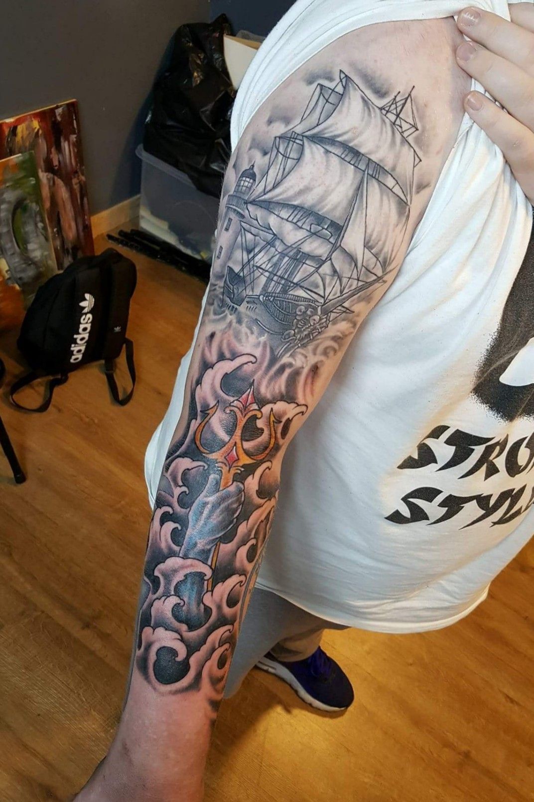 Black and grey Poseidon tattoo on the left upper arm