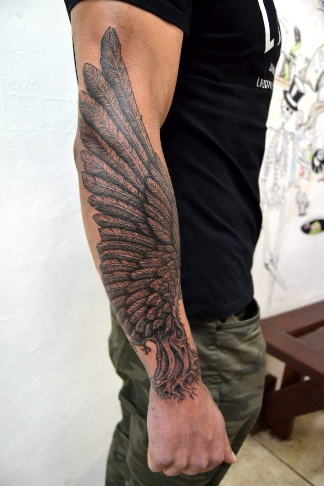 Crow wings tattooed on the top of shoulder