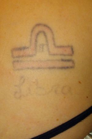 Very faded tattoo that an ex-boyfriend did. It was the very first attempt of his at doing a tattoo. Its located on my right side of my back. Kind of below the shoulder blade. Its (obviously) one of the symbols for a Libra, with "Libra" underneath in cursive writing, and in the center of the symbol there is a tiny Roman numeral for the number 2 because I am a twin. 