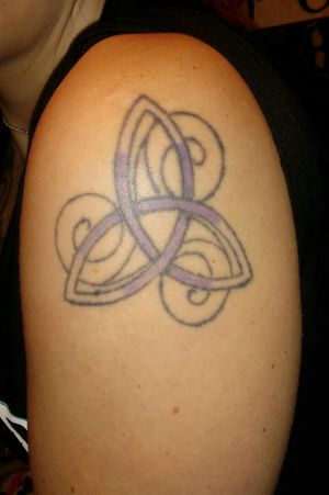 This is a trinity knot which is also a Celtic knot for sisters. I got it on my upper left arm just below the shoulder. My twin sister has the exact same one on her right arm only her's is blue. It is my only professional tattoo done in an actual shop somewhere in SLC, UT. 