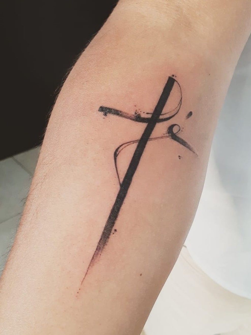 Fé lettering tattoo in the shape of a cross
