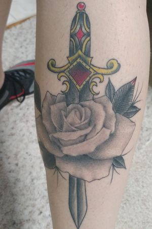 Black and gray rose with a traditional style dagger through it. 