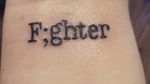 I want a tattoo similar to this on my left wrist . I want the word fighter to be written in cursive and withought the ; . 