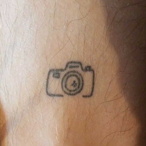 Little camera tattoo located on the finger