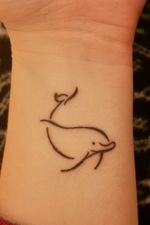 This simple, line work, dolphin is on my left wrist. My first tattoo.