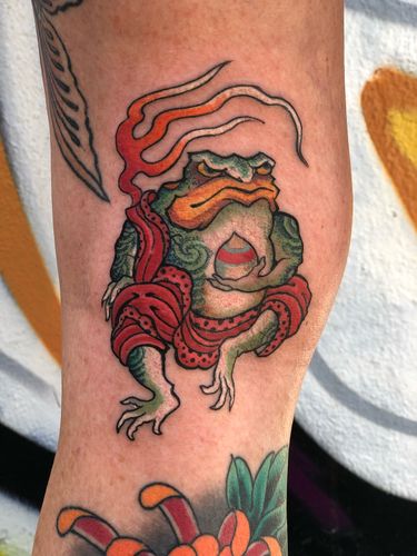 Get a unique and traditional Japanese frog tattoo on your knee by the renowned artist Ami James. Embrace symbolism and artistry in this stunning design.