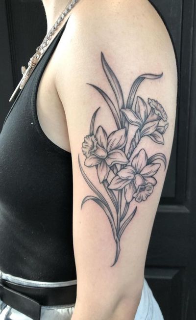 Beautiful illustrative daffodil flower tattoo by artist Amandine Canata, perfect for nature lovers.
