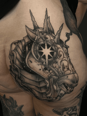 A powerful black and gray tattoo by Kat Jennings featuring a stoic horse adorned in armor, embodying the essence of a death knight.