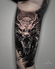 Japanese Dragon – Inner Arm Tattoo A powerful black and grey realism piece depicting a Japanese dragon in motion. The detailed scales and intense expression embody strength, wisdom, and protection. Tattoo by London artist Roudolf Dimov.