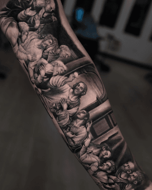 Black and gray tattoo of Jesus and his disciples at the Last Supper, expertly done by Ember with a focus on religious realism.