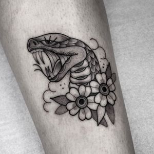 Get inked with a stunning illustrative design featuring a snake and flower by renowned artist Barbara Nobody.