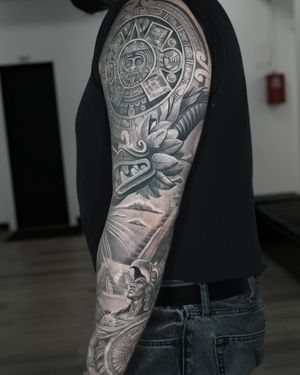 Detailed black and gray tattoo of Quetzalcoatl, the Aztec god depicted as a serpent, done in a realistic style by Ember.