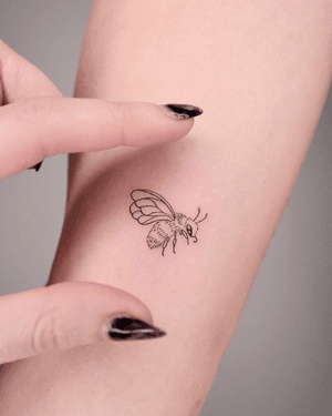 Delicate fine line bee tattoo done by Ayala, featuring minimal design.