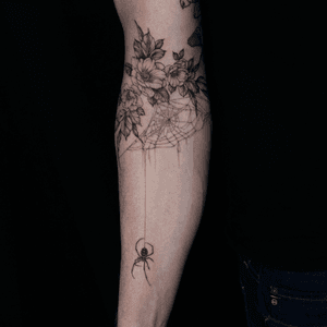 Fine line black and gray tattoo of a spider, black widow, flower, and web by Sasha Davydova.