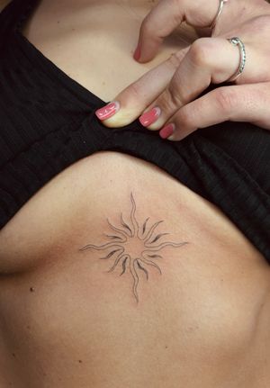 Delicate and dainty fine line ornamental sun tattoo by Ellie Shearer.