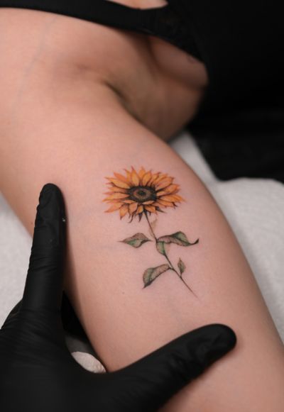 Embrace the beauty of nature with this stunning micro-realism tattoo featuring a colorful sunflower, expertly done by the talented artist Maria.