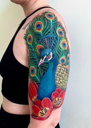 A realistic peacock tattoo in full color, beautifully capturing the intricate details of the majestic bird. Located in New York, US.