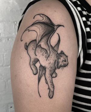 Captivating blackwork tattoo by Claudia Smith featuring a devil, lynx, and wings. Intricate and powerful design.