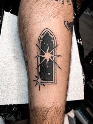 Experience the universe through Alexandra Mulhall's mesmerizing blackwork star and window tattoo design.