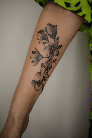 Finelined, black and grey elegant magnolia arm tattoo