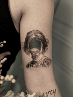 A haunting surreal portrait tattoo in black and grey realism, featuring a figure with an empty face shaped like a distorted reflection. Executed in refined micro realism tattoo technique with precise shading and fine line detailing, this introspective surrealist composition explores identity, absence and emotional depth within a dreamlike aesthetic.