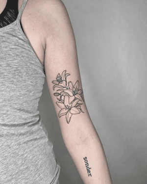 Fine line floral tattoo by Marissa Boulay, featuring intricate botanical motifs.