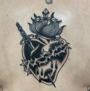 Experience the timeless beauty of a black and gray traditional sacred heart tattoo, expertly crafted by artist Megan Foster.